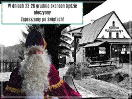 Pod dachem zabytkowego zajazdu święty Mikołaj - biskup uśmiecha się dobrotliwie. W tle budynek kuźni i wyraźny napis 